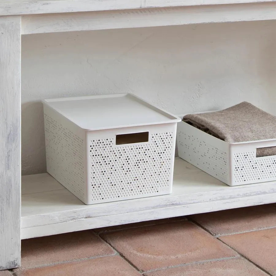 White lidded storage boxes with a perforated pattern under a shelf