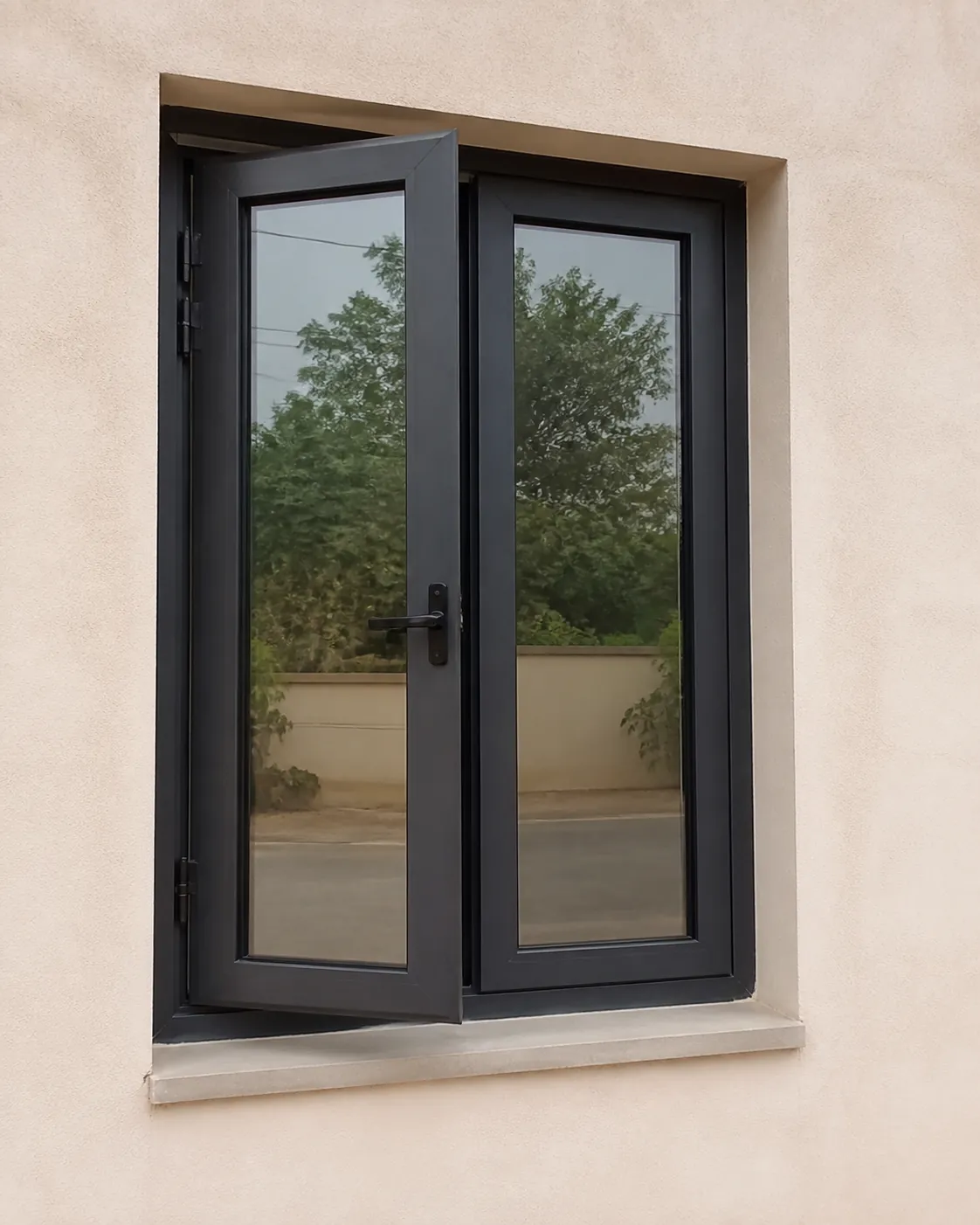Two-sash anthracite aluminium casement window on a beige rendered facade
